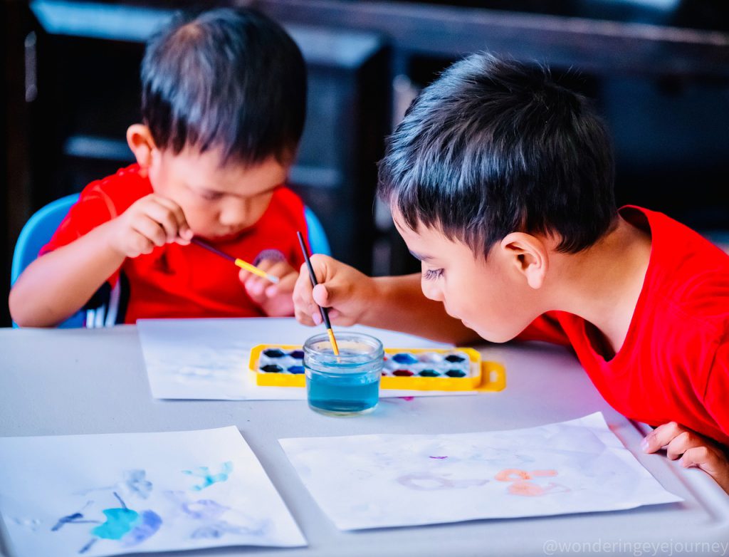 two young boys painting with watercolors