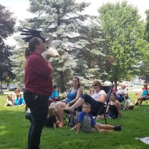 Hawk Creek animal handler talks to program attendees on the school lawn