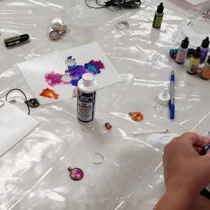 cabochon charms, earrings, ink bottles, glue and colorful paper