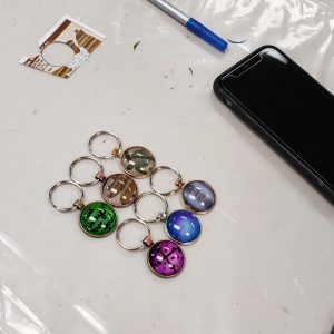 6 cabochon keychains with various images and writing