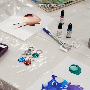 4 cabochon keychains, ink bottles, and inked paper