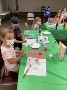 children work on their animal portraits using storybooks for reference