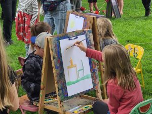 children painting at wooden easels