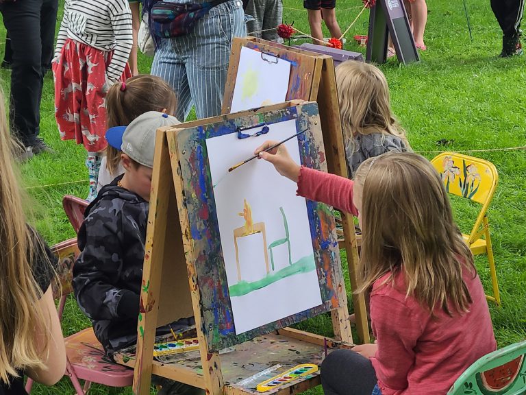children painting at wooden easels