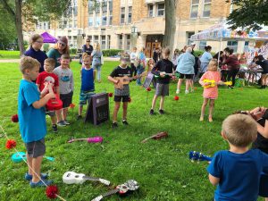 children with colorful ukuleles learn to play