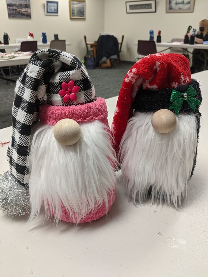 one gnome with black and white checked hat, one gnome with red hat with snowflake pattern.