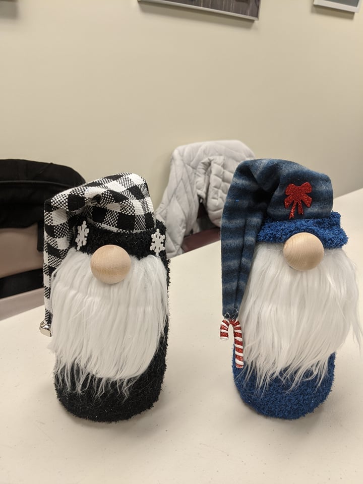 one gnome with black and white checked hat, one gnome with blue striped hat