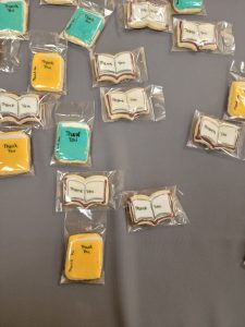 Cookies shaped like open and closed books with "thank you" written on them.