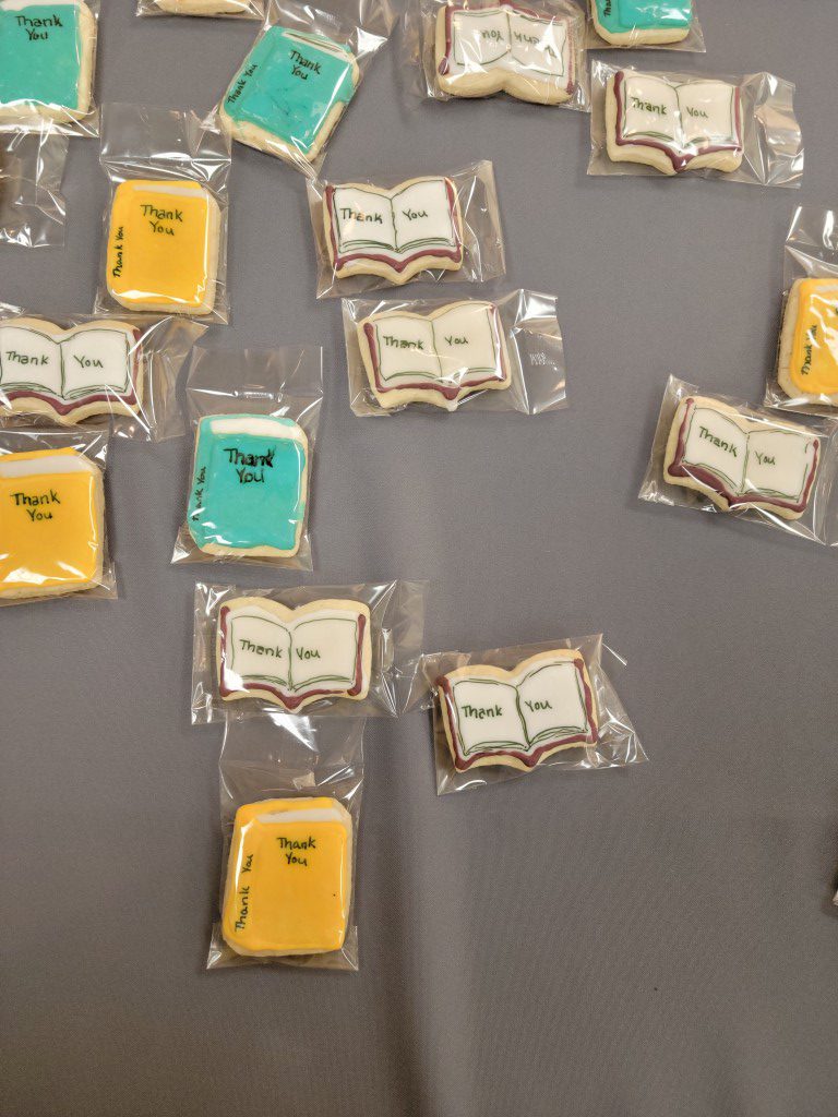 Cookies shaped like open and closed books with "thank you" written on them.