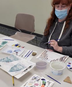 Red haired woman works on winter landscape of trees