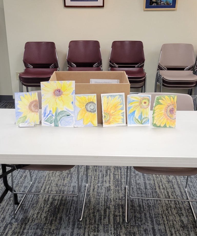 display of finished sunflower paintings completed by the class