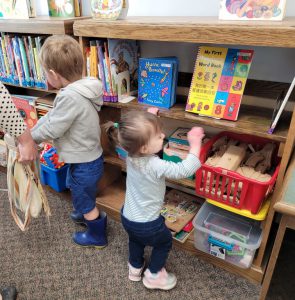 young boy and girl look for eggs in the library