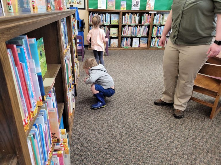 young boy crouches to look for Easter eggs