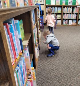 young boy crouches to look for Easter eggs