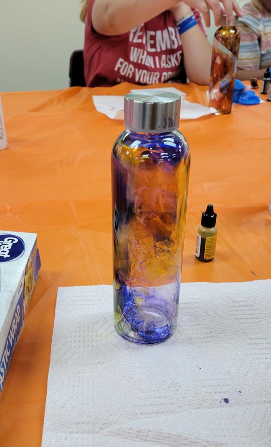 bottle with ink patterns in blue, yellow, purple