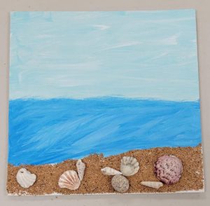 a beach scene with a crushed walnut shell beach and seashell embellishments