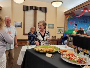 several people converse near a display of hors d'oeuvres