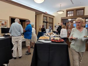 several people converse near a display of hors d'oeuvres