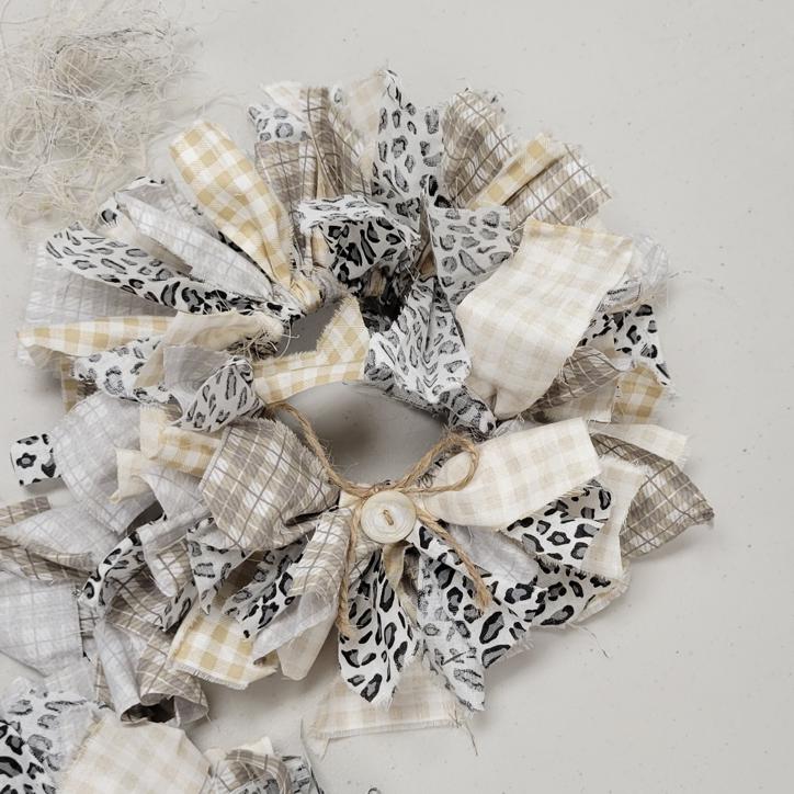 wreath made with strips of fabric in tan gingham, khaki plaid, and white with grey leopard print
