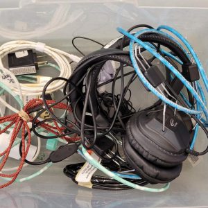 clear plastic bin of assorted headphones and cables