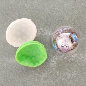 round robot with clear shell and visible internal components pictured with white and lime green silicone protective cases.