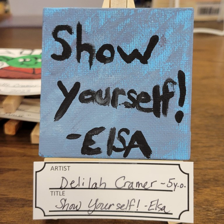 painting of blue and purple background with lettering "Show Yourself!" - Elsa
