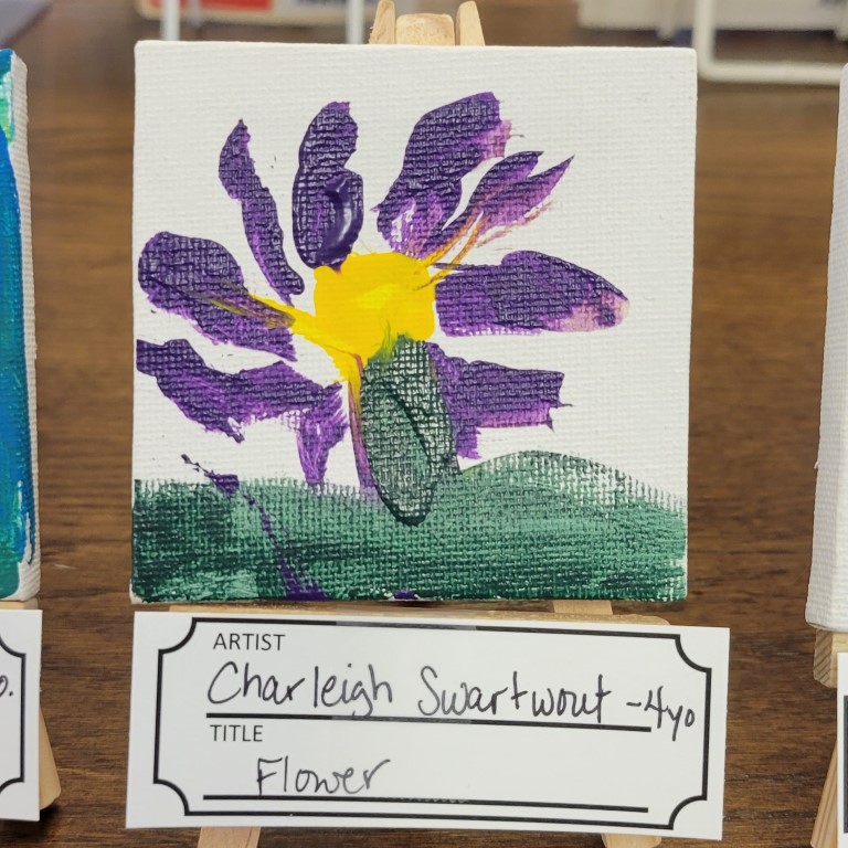 painting of flower with purple petals & yellow center, and green grass