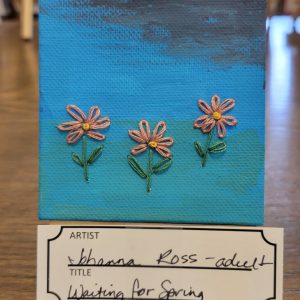 painting with black, blue, and blue-green background and 3embroidered pink and orange flowers.