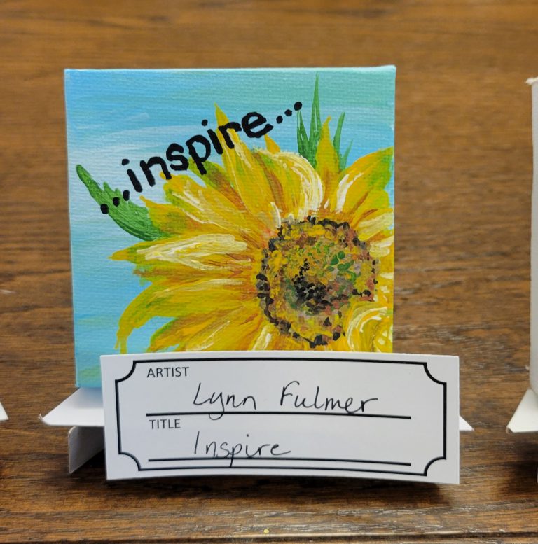 blue painting with yellow orange brown and green sunflower with ...inspire... text