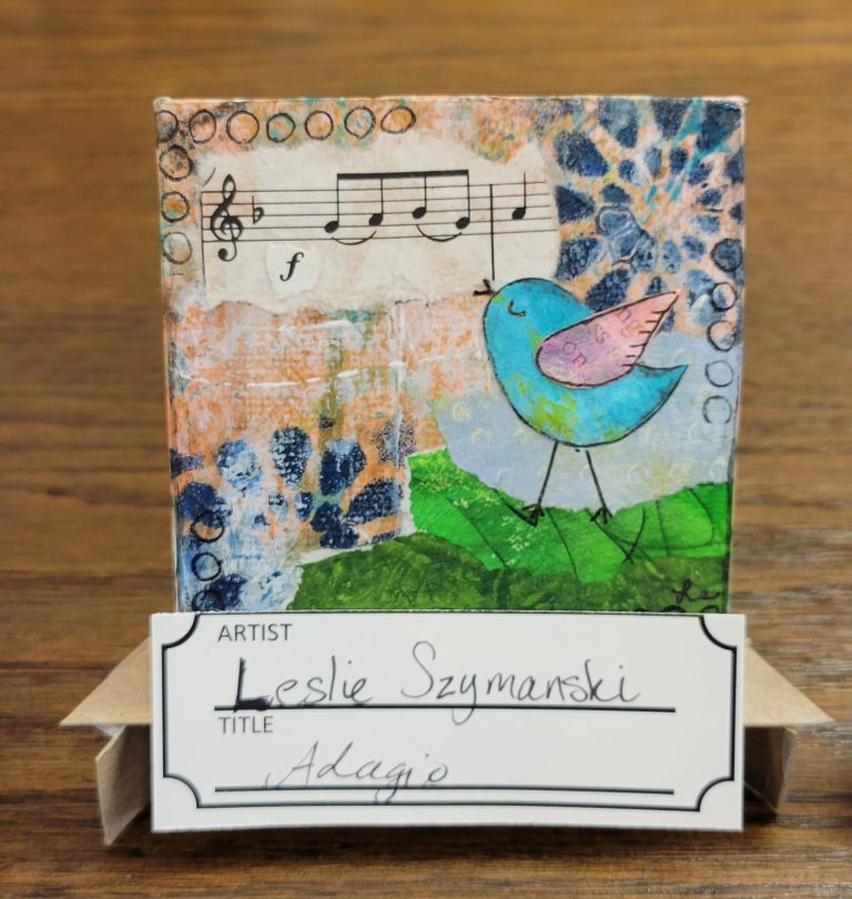 decoupaged mixed media with music notes, blue raindrop shapes, green in lower right corner, and a cartoon bird in blue and pink