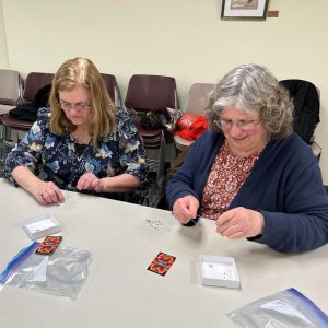 two ladies string beads for their bracelets