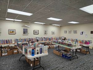 room with tables of books and boxes of books underneath