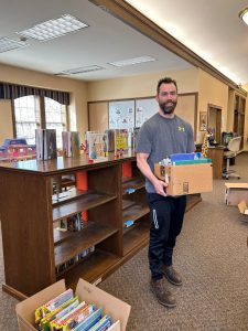 man holding box of books