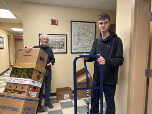 teenage boy with moving dolly and man with loaded moving dolly