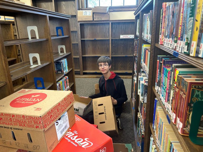 teenage boy sitting on floor with boxes