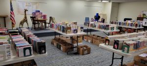 books on tables, dollhouse and other toys on stage at side of room