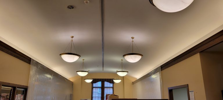 curved ceiling with hanging pendant lights and lit ledges