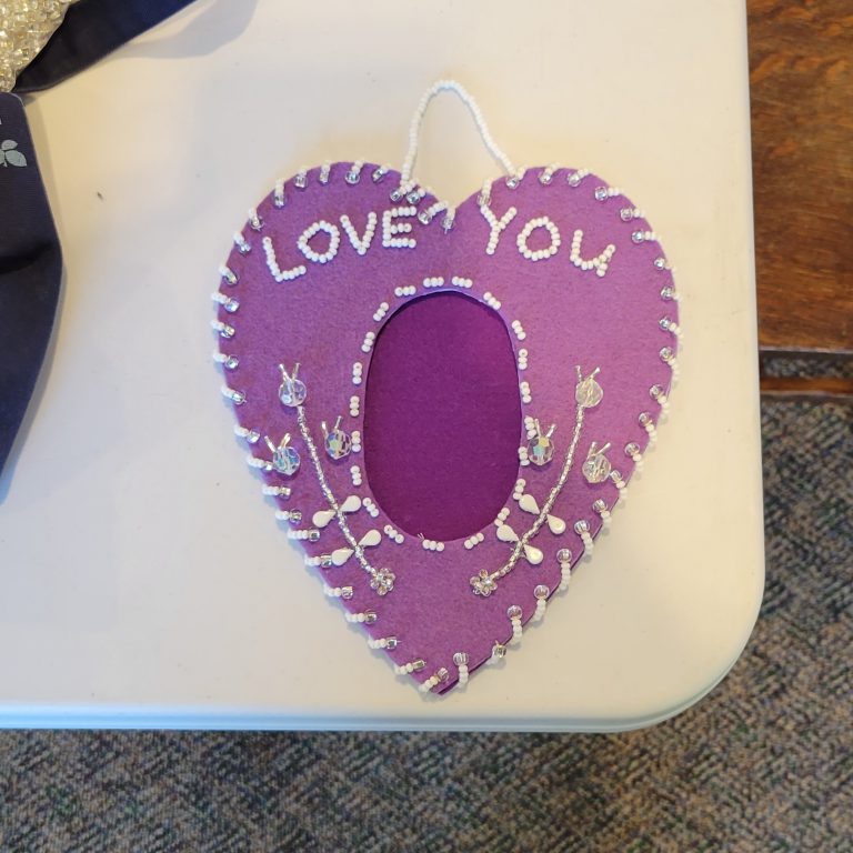 light purple felt in heart shape with darker purple felt oval in center and clear and white beaded design