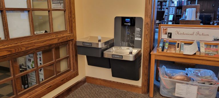 two water fountains mounted on wall at different heights, one with water bottle filler