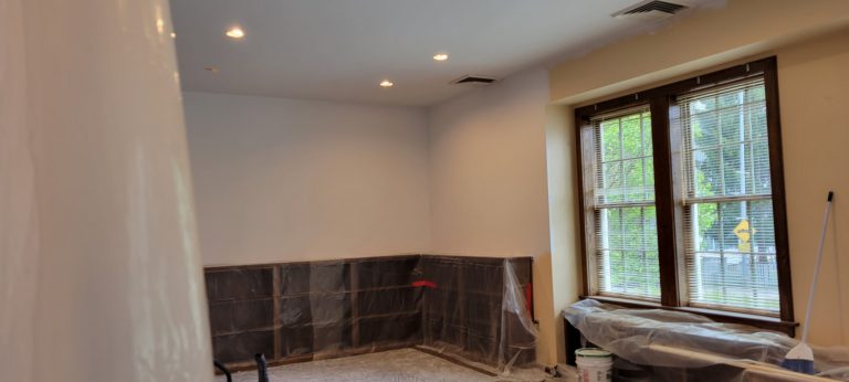 room with white ceiling and section of white wall with remainder of wall in beige