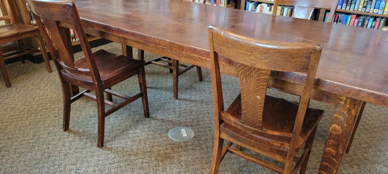 wooden table with blank metal circle screwed into floor