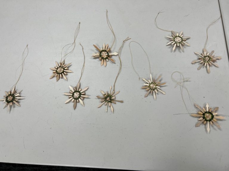 nine star or snowflake shaped ornaments woven with sweetgrass and black ash splint
