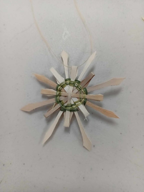 star or snowflake shaped ornament woven with green sweetgrass and black ash splint