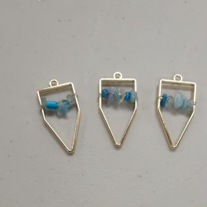 gold bezels with turquoise, light blue and clear crystal chips strung on wire across the center