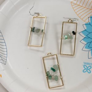 long gold rectangular bezels with green, white and clear crystal chips strung on wire across the center