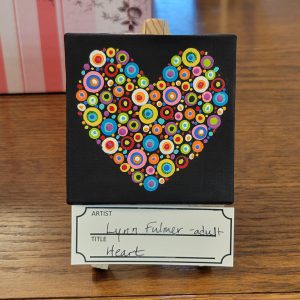 heart made up of colorful dots in a rainbow of colors on black canvas