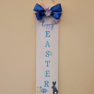 rectangular sign with happy easter, a dark grey bunny, and yellow and blue easter eggs painted on and a blue and multicolored plaid bow