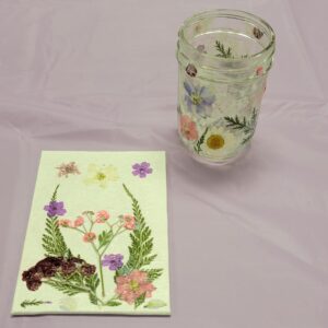 small glass jar and canvas with pink purple and white pressed flowers and leaves