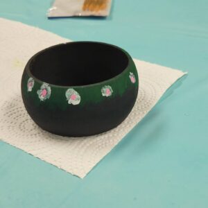 black bangle with white pink and purple flowers on a grassy border