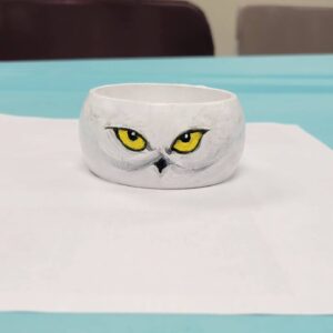 white bangle with yellow owl eyes and black beak